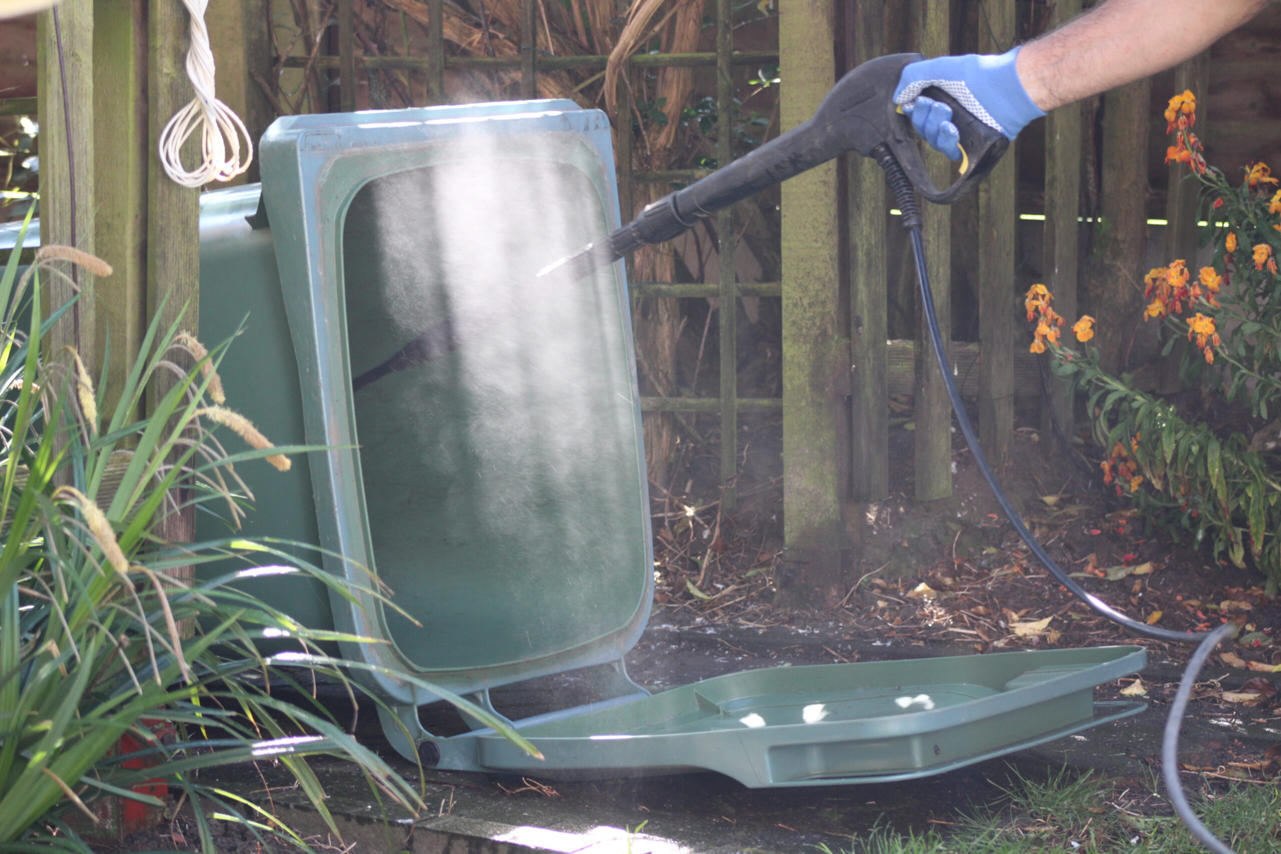 Garbage Can Cleaning - jet washing the wheely bin